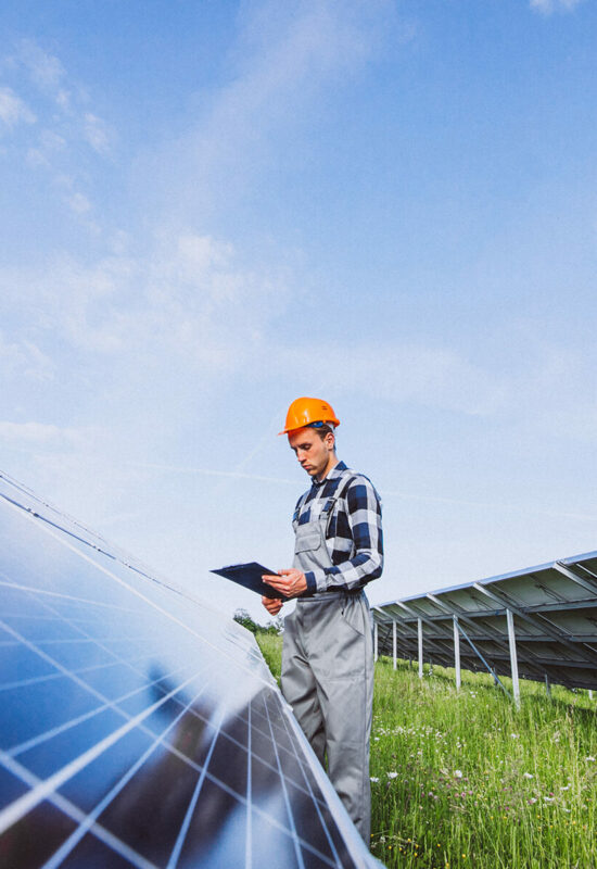 Man worker in the firld by the solar panels